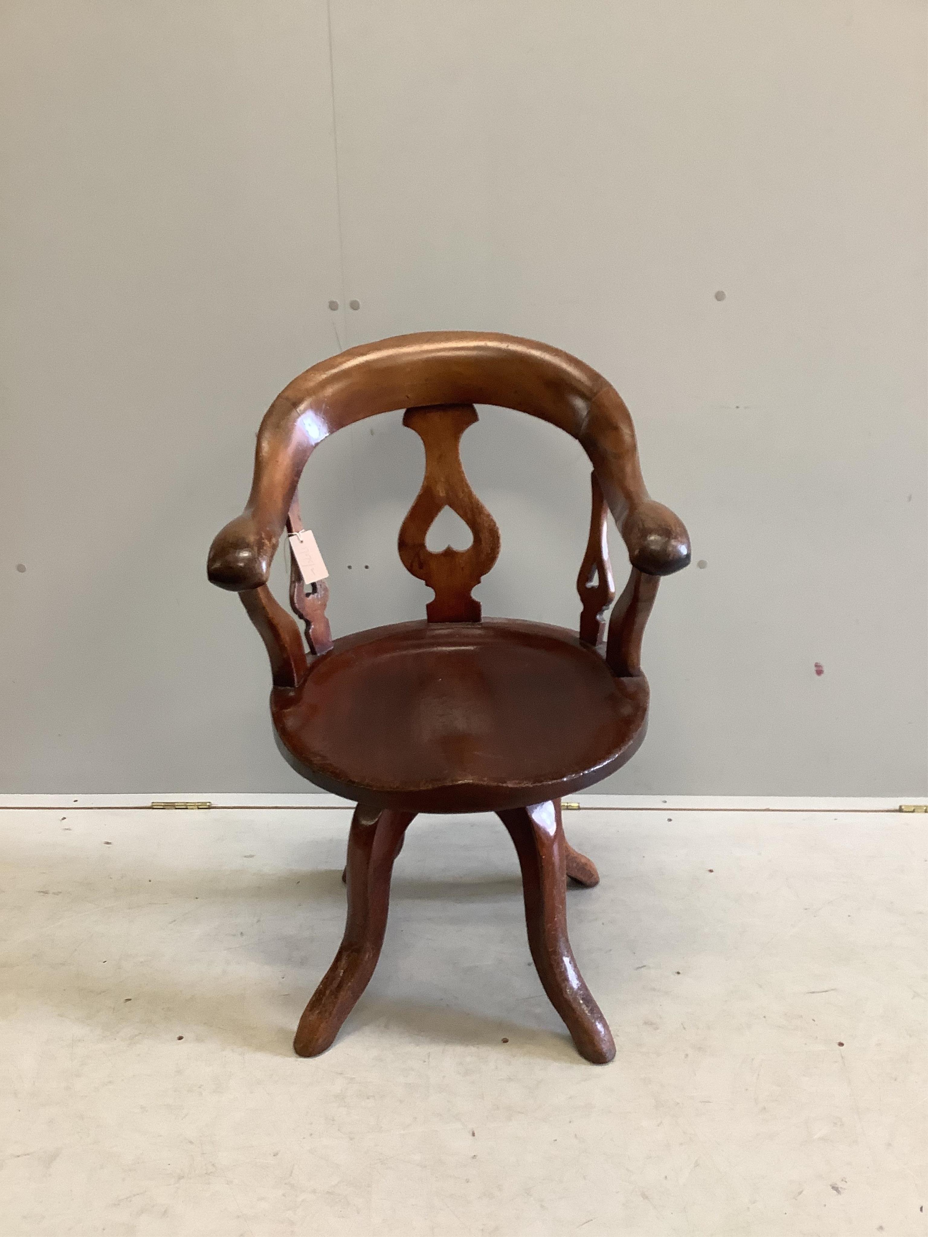 A Victorian mahogany desk chair with scroll arms, on swivel base, width 55cm, depth 50cm, height 88cm. Condition - fair